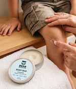 Parent applying Bear Basics Coconut Oil Body Bar to a child's knee