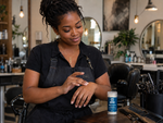 Hair stylist applying Bear Basics Beef Tallow Body Balm at her salon station