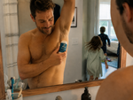 Dad applying Bear Basics Beef Tallow Deodorant while his kids play in the next room