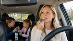 Mom applying Bear Basics Beef Tallow Lip Balm on a family car trip